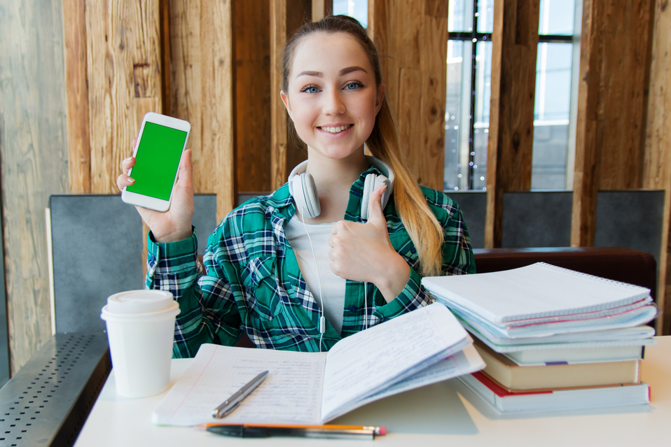 Smiling Woman Holding White Android Smartphone While Sitting Front of Table